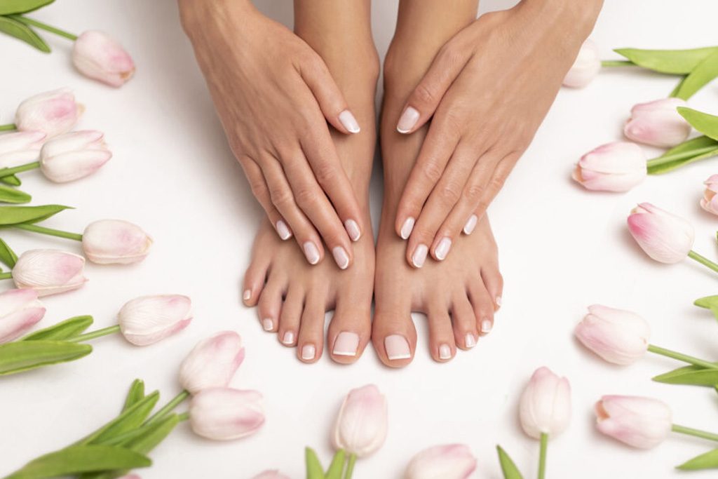 Female hands and feet with perfect done pedicure.
